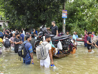 People wade through floodwaters in the Mohipal area of Feni district in Chittagong division, Bangladesh, on August 23, 2024. At least 13 peo...