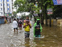 People wade through floodwaters in the Mohipal area of Feni district in Chittagong division, Bangladesh, on August 23, 2024. At least 13 peo...