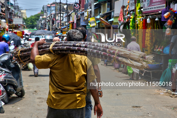 A man carries sugarcane in the Chalai market in Thiruvananthapuram, Kerala, India, on April 13, 2024. The Chalai Market (Chalai bazaar) is K...