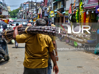 A man carries sugarcane in the Chalai market in Thiruvananthapuram, Kerala, India, on April 13, 2024. The Chalai Market (Chalai bazaar) is K...