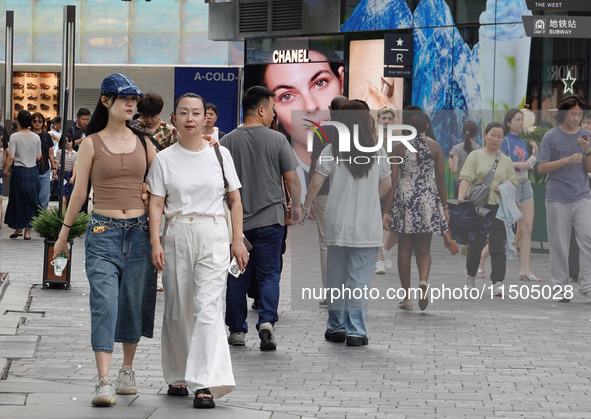 People visit Taikoo Li, a trendy fashion district in Sanlitun, in Beijing, China, on August 18, 2024. 