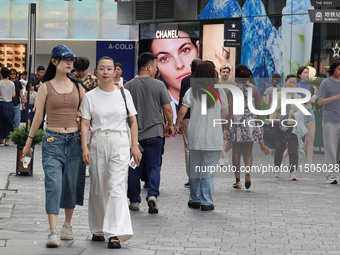 People visit Taikoo Li, a trendy fashion district in Sanlitun, in Beijing, China, on August 18, 2024. (