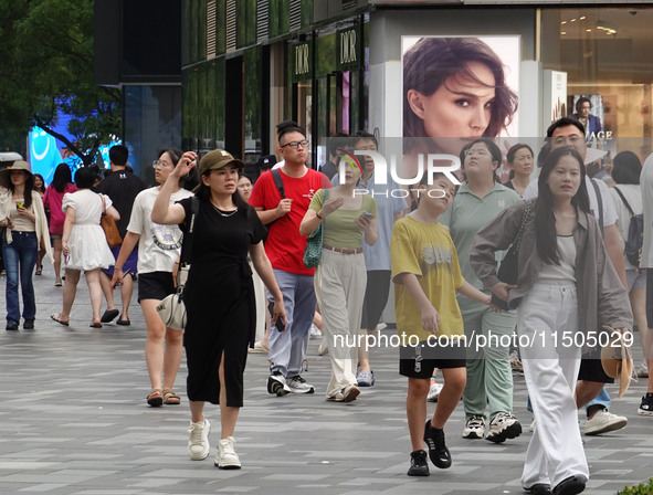 People visit Taikoo Li, a trendy fashion district in Sanlitun, in Beijing, China, on August 18, 2024. 