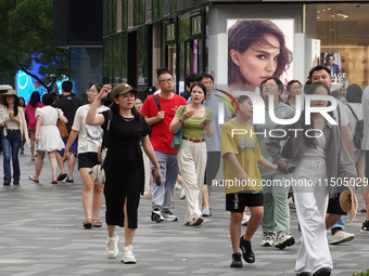 People visit Taikoo Li, a trendy fashion district in Sanlitun, in Beijing, China, on August 18, 2024. (