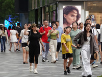 People visit Taikoo Li, a trendy fashion district in Sanlitun, in Beijing, China, on August 18, 2024. (