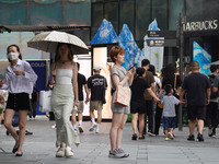 People visit Taikoo Li, a trendy fashion district in Sanlitun, in Beijing, China, on August 18, 2024. (