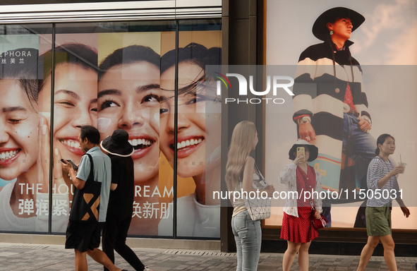 People visit Taikoo Li, a trendy fashion district in Sanlitun, in Beijing, China, on August 18, 2024. 