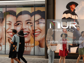 People visit Taikoo Li, a trendy fashion district in Sanlitun, in Beijing, China, on August 18, 2024. (