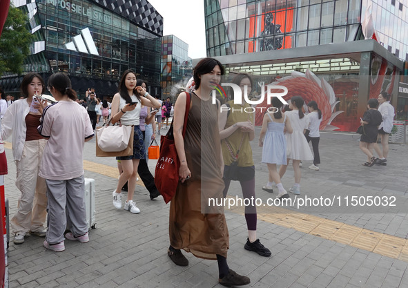 People visit Taikoo Li, a trendy fashion district in Sanlitun, in Beijing, China, on August 18, 2024. 