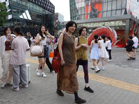 People visit Taikoo Li, a trendy fashion district in Sanlitun, in Beijing, China, on August 18, 2024. (