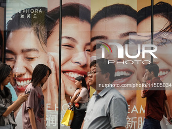 People visit Taikoo Li, a trendy fashion district in Sanlitun, in Beijing, China, on August 18, 2024. (