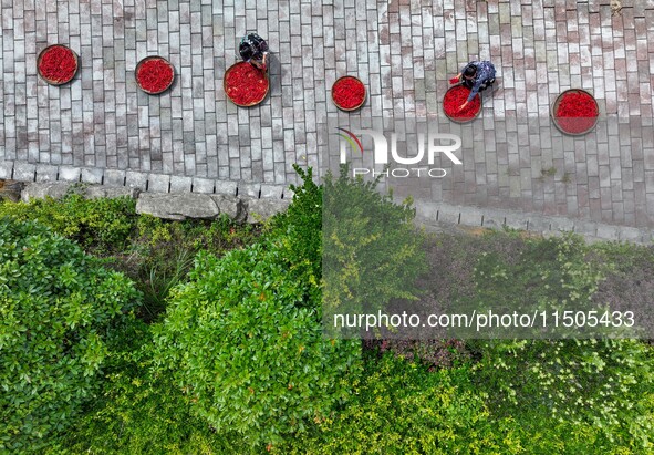 Villagers dry chili peppers and corn in Miaoluo village in Qiandongnan Miao and Dong autonomous Prefecture in Qiandongnan, China, on August...