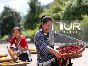 Villagers dry chili peppers and corn in Miaoluo village in Qiandongnan Miao and Dong autonomous Prefecture in Qiandongnan, China, on August...