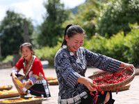 Villagers dry chili peppers and corn in Miaoluo village in Qiandongnan Miao and Dong autonomous Prefecture in Qiandongnan, China, on August...