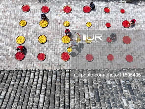 Villagers dry chili peppers and corn in Miaoluo village in Qiandongnan Miao and Dong autonomous Prefecture in Qiandongnan, China, on August...