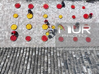 Villagers dry chili peppers and corn in Miaoluo village in Qiandongnan Miao and Dong autonomous Prefecture in Qiandongnan, China, on August...