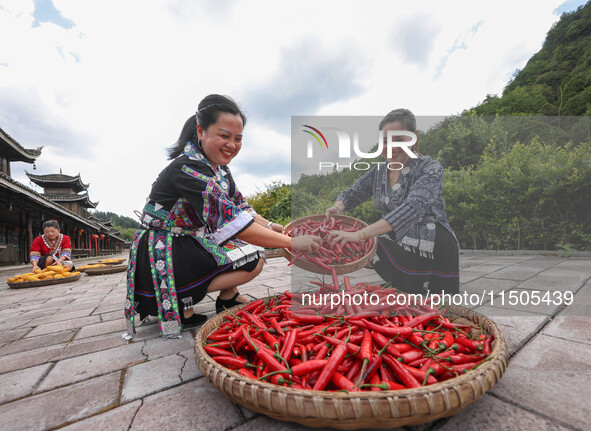 Villagers dry chili peppers and corn in Miaoluo village in Qiandongnan Miao and Dong autonomous Prefecture in Qiandongnan, China, on August...