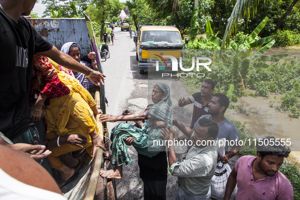 Local volunteers rescue elderly women trapped in floods to safety in Bishumiar Hat, Mirsarai, Bangladesh, in the southeastern region of Bang...