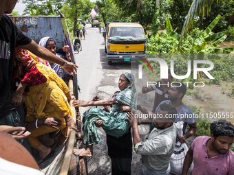 Local volunteers rescue elderly women trapped in floods to safety in Bishumiar Hat, Mirsarai, Bangladesh, in the southeastern region of Bang...