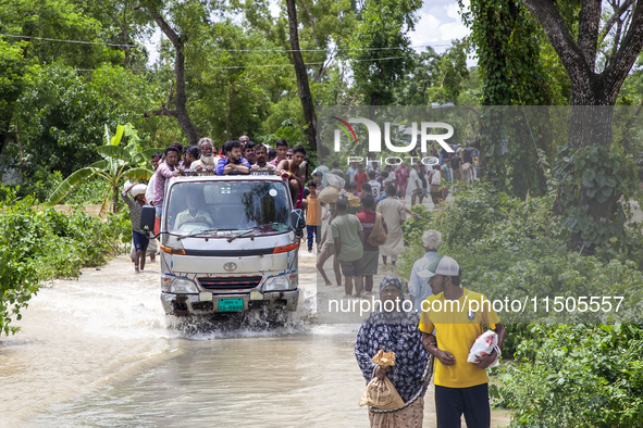 Local volunteers rescue people trapped by floods and take them to safety by car in Bishumia Hat, Mirsarai, southern Bangladesh, in Mirsarai,...