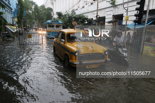 Vehicles drive through a flooded street during the heavy monsoon rain in Kolkata, India, on August 24, 2024. 