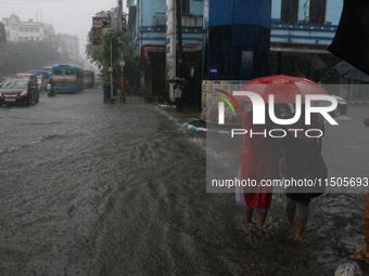 Vehicles drive through a flooded street during the heavy monsoon rain in Kolkata, India, on August 24, 2024. (