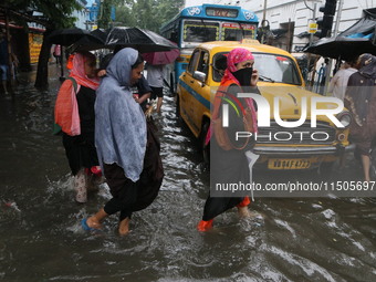 People walk on a flooded street during the heavy monsoon rain in Kolkata, India, on August 24, 2024. (