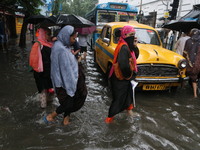 People walk on a flooded street during the heavy monsoon rain in Kolkata, India, on August 24, 2024. (