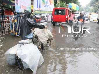 People walk on a flooded street during the heavy monsoon rain in Kolkata, India, on August 24, 2024. (