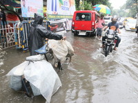 People walk on a flooded street during the heavy monsoon rain in Kolkata, India, on August 24, 2024. (