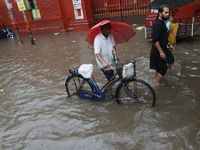 People walk on a flooded street during the heavy monsoon rain in Kolkata, India, on August 24, 2024. (