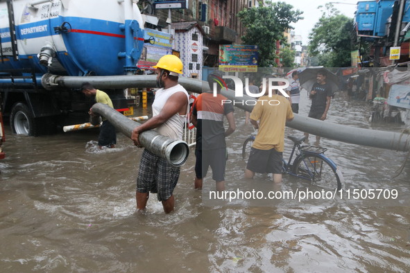 People walk on a flooded street during the heavy monsoon rain in Kolkata, India, on August 24, 2024. 