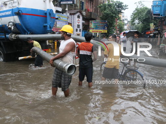 People walk on a flooded street during the heavy monsoon rain in Kolkata, India, on August 24, 2024. (