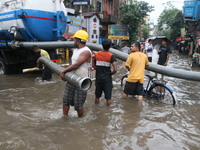 People walk on a flooded street during the heavy monsoon rain in Kolkata, India, on August 24, 2024. (