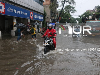 People walk on a flooded street during the heavy monsoon rain in Kolkata, India, on August 24, 2024. (