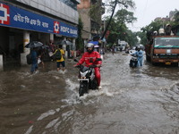 People walk on a flooded street during the heavy monsoon rain in Kolkata, India, on August 24, 2024. (