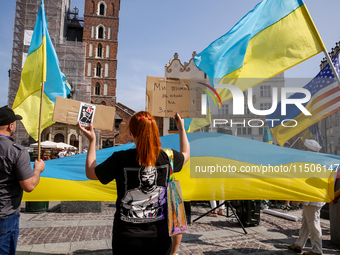 Members of Ukrainian diaspora chant slogans and hold Ukrainian flags during a demonstration on Ukrainian Independence Day  on the Main Squar...