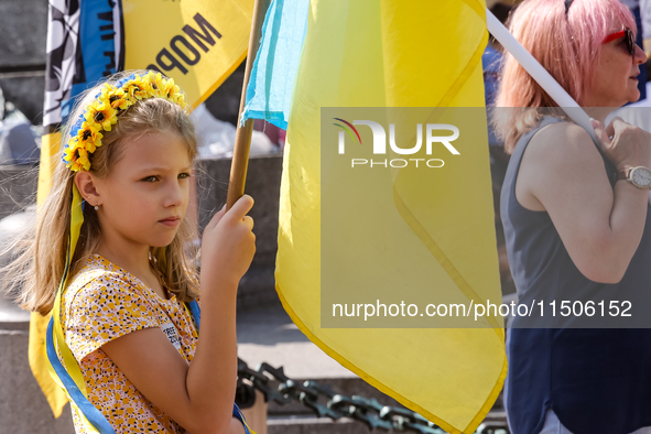 Members of Ukrainian diaspora chant slogans and hold Ukrainian flags during a demonstration on Ukrainian Independence Day  on the Main Squar...