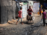 Displaced Palestinian children carry containers to fill with water at a makeshift displacement camp in Deir el-Balah in the central Gaza Str...