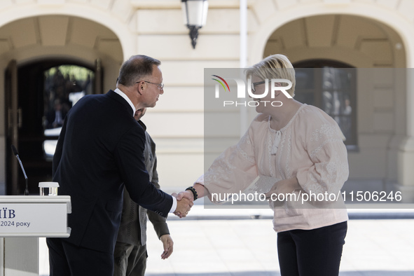 Polish President Andrzej Duda and Lithuanian Prime Minister Ingrida Simonyte shake hands after a joint press conference with Ukraine's Presi...