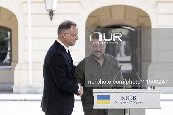 Ukrainian President Volodymyr Zelenskiy and Polish President Andrzej Duda embrace after a joint press conference with Lithuanian Prime Minis...