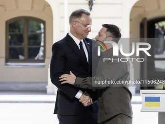 Ukrainian President Volodymyr Zelenskiy and Polish President Andrzej Duda embrace after a joint press conference with Lithuanian Prime Minis...