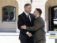 Ukrainian President Volodymyr Zelenskiy and Polish President Andrzej Duda embrace after a joint press conference with Lithuanian Prime Minis...