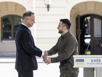 Ukrainian President Volodymyr Zelenskiy and Polish President Andrzej Duda shake hands after a joint press conference with Lithuanian Prime M...