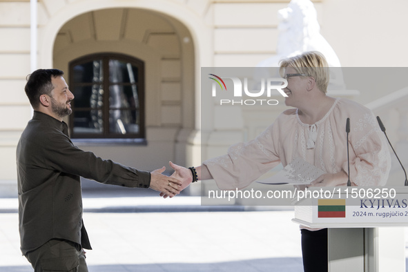 Ukraine's President Volodymyr Zelenskiy and Lithuanian Prime Minister Ingrida Simonyte shake hands after a joint press conference with Polis...