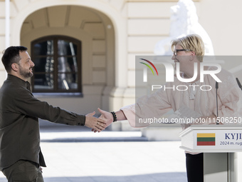 Ukraine's President Volodymyr Zelenskiy and Lithuanian Prime Minister Ingrida Simonyte shake hands after a joint press conference with Polis...