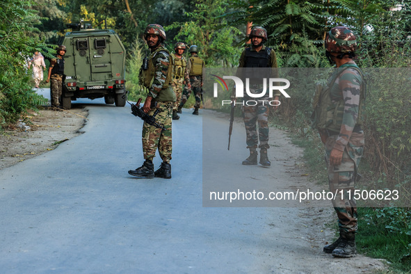 Indian Army soldiers stand alert after an encounter breaks out between militants and security forces in which one militant is killed in Wate...