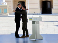 President of Ukraine Volodymyr Zelenskyy hugs President of Poland Andrzej Duda during a joint news conference outside the Mariinskyi Palace...