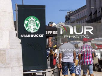 A general view of people walking by a Starbucks Coffee store in Lisbon, Portugal, on August 24, 2024. Brian Niccol, CEO of Starbucks startin...