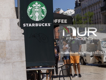 A general view of people walking by a Starbucks Coffee store in Lisbon, Portugal, on August 24, 2024. Brian Niccol, CEO of Starbucks startin...